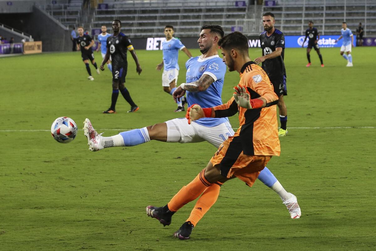 New York City FC midfielder Valentin Castellanos (11) kicks the ball next to CF Montreal goalkeeper James Pantemis (41) during the first half of an MLS soccer match Wednesday, July 7, 2021, in Orlando, Fla. (AP Photo/Gary McCullough)