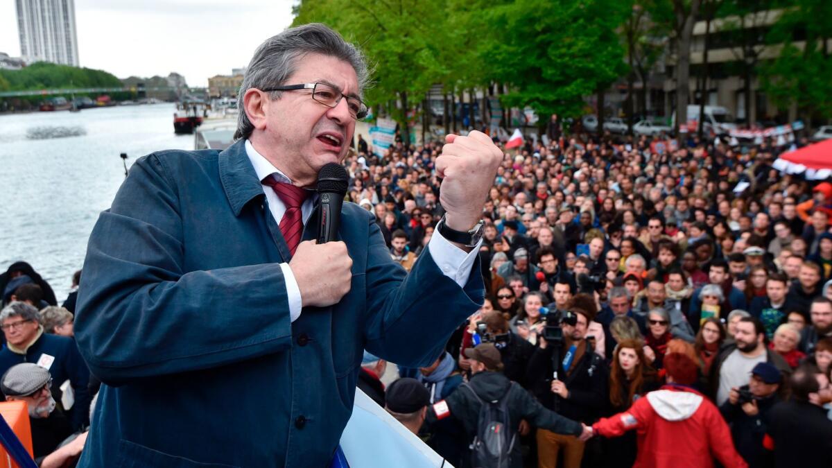 French presidential candidate Jean-Luc Melenchon gives a speech aboard a barge Monday in Paris, part of campaign meetings along the Seine river.