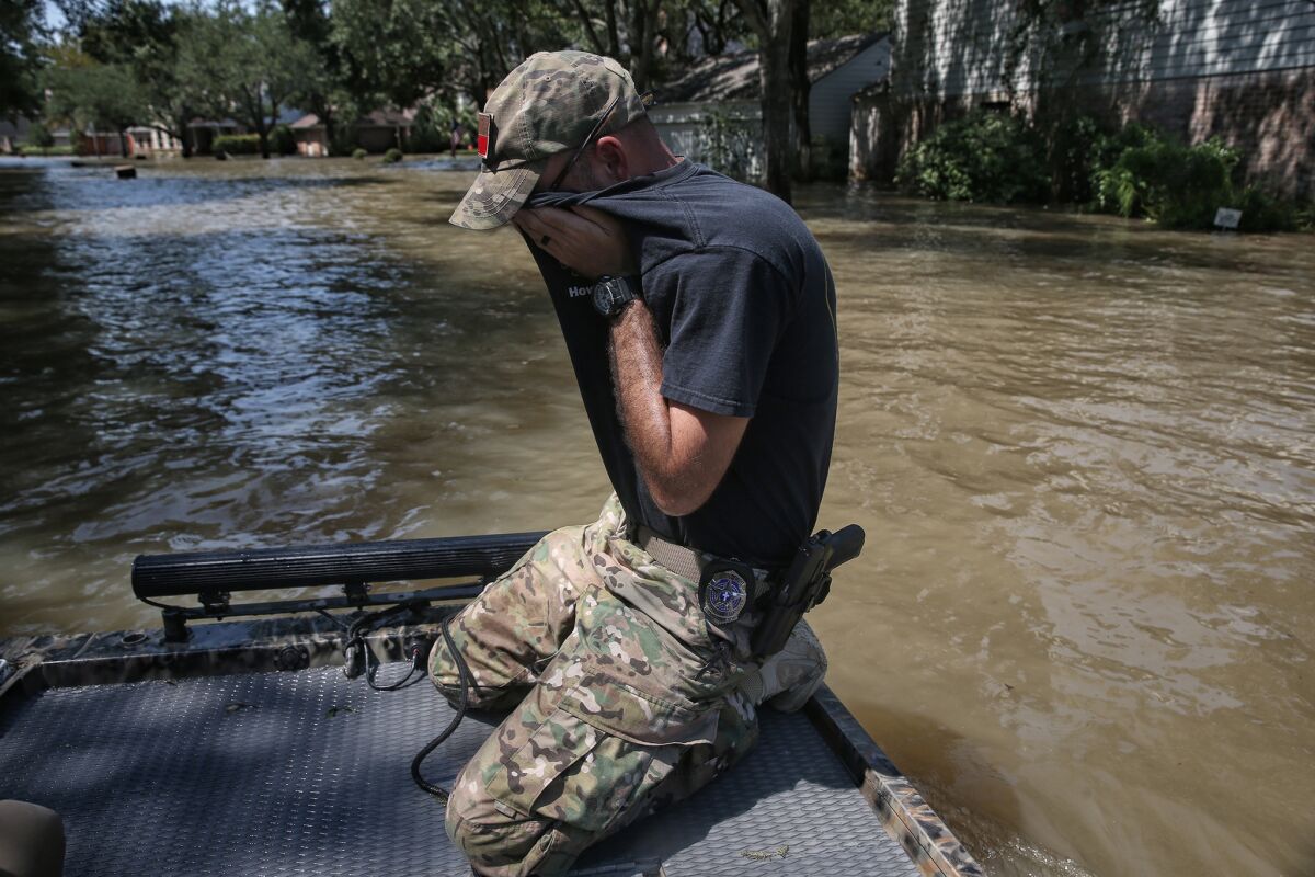 Wes Higgins wipes sweat from his face as he finishes the last of five days of patrolling flooded neighborhoods in his own boat.