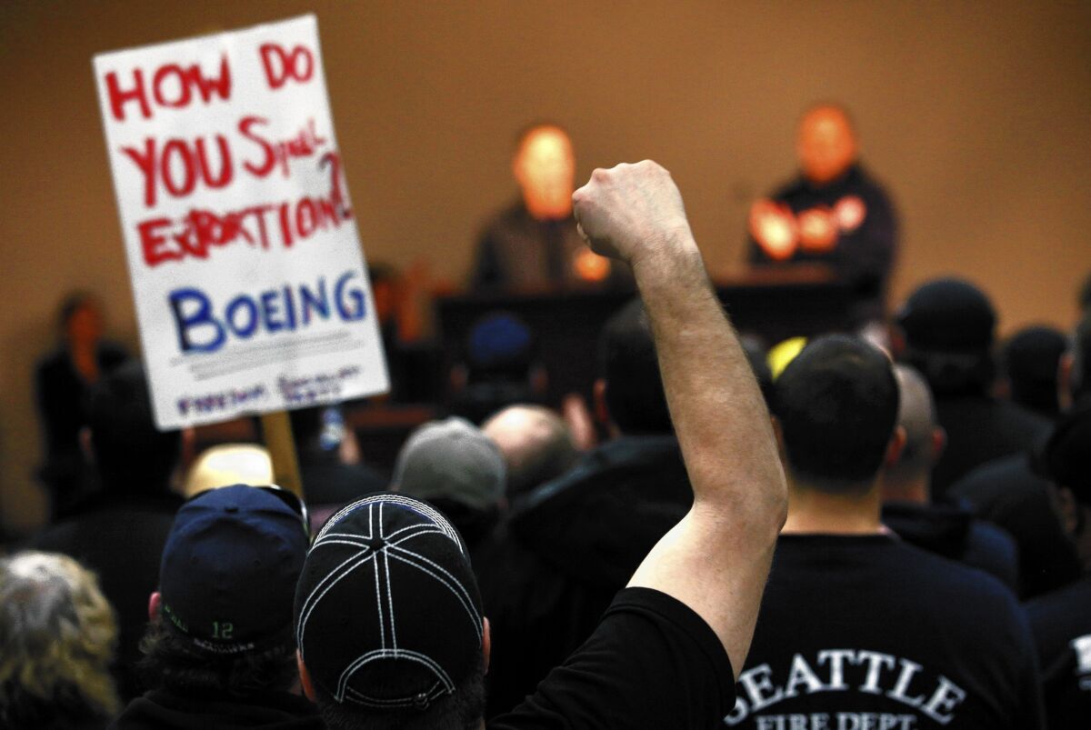Seattle-area machinist union members rally against a contract with Boeing that included concessions on pensions. In the end, members narrowly approved it after Boeing threatened to take production of the new 777X airliner to another state.