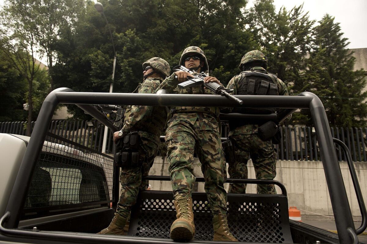 Mexican marines patrol near the Deputy Attorney Specialized in Investigation of Organized Crime (SEIDO) headquarters in Mexico City after the arrest of Zetas gang leader Miguel Angel Trevino Morales.