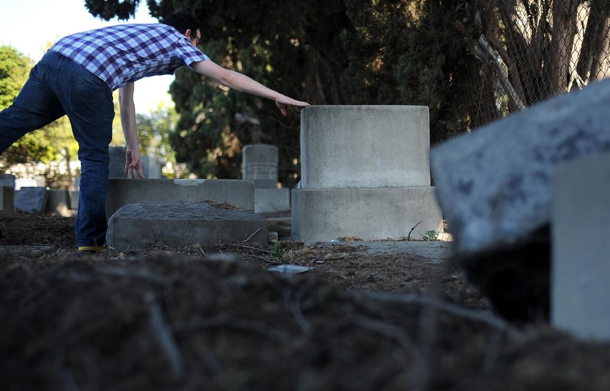 Rob Adler-Peckerar touches the headstone of writer Lamed Shapiro at the Mt. Zion Cemetary in East Los Angeles