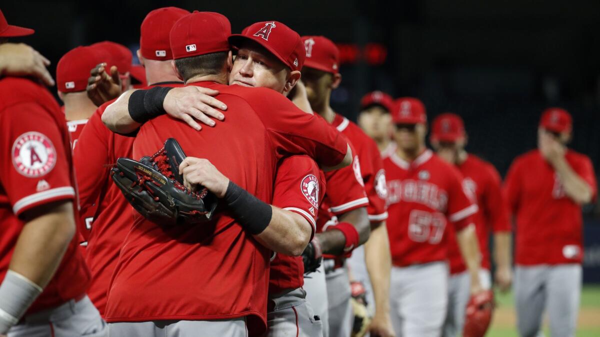 Angels' Kole Calhoun, center, hugs a teammate after the Angels' 9-4 win against the Texas Rangers in Arlington, Texas, on Tuesday.