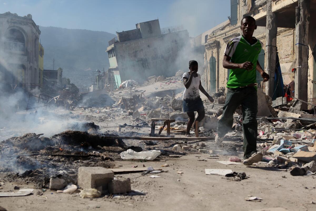 Haitians run past burning ruins in Port-au-Prince after the earthquake on Jan. 12, 2010. 