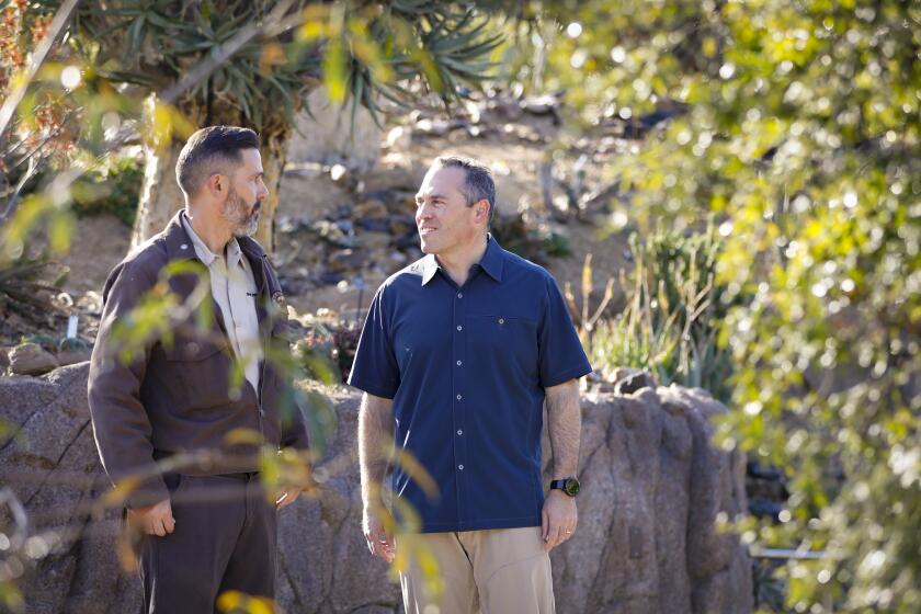 Patrick Smith, senior horticulturalist at the San Diego Zoo, left, gives Paul Baribault, right, the new president and CEO of San Diego Zoo Global, tour of the African Garden section in the Africa Rocks exhibit at the zoo, November 5, 2019.