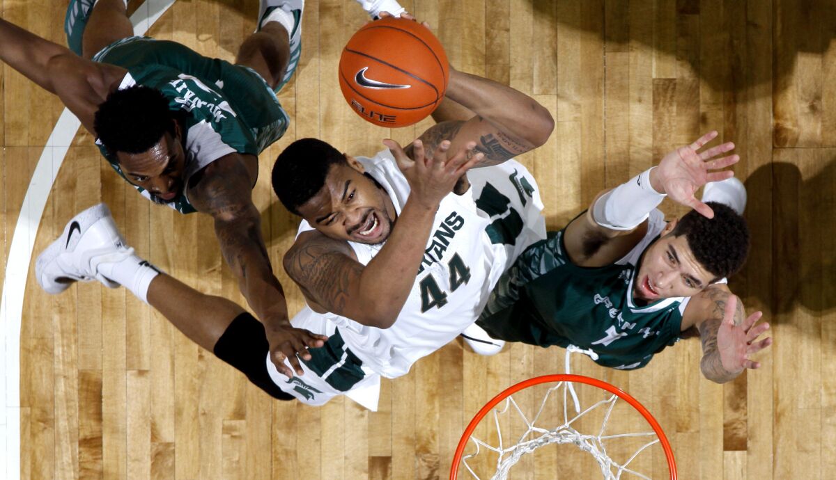 Michigan State's Nick Ward tries to score between Green Bay's Josh McNair, left, and Sandy Cohen III, during the first half Sunday.
