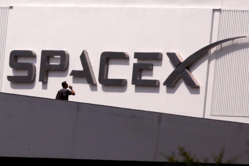 HAWTHORNE, CA - JULY 17, 2024 - An employee walks across the bridge from parking to SpaceX in Hawthorne on July 17, 2024. Elon Musk said Tuesday on X that he is moving the headquarters of both SpaceX and the social media platform formerly known as Twitter to Texas - citing several criticisms he has of California. (Genaro Molina/Los Angeles Times)