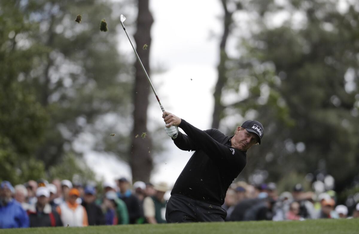 Phil Mickelson hits a shot on the fourth hole.