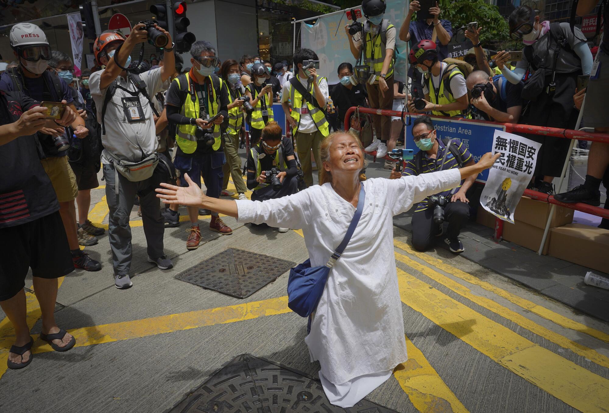 A woman prays in front of police before the annual handover march in Hong Kong on Wednesday.