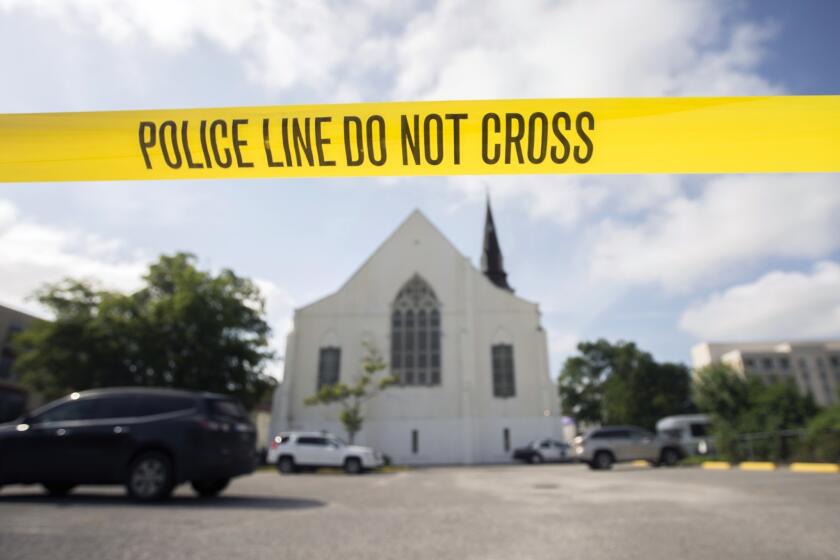 Police tape surrounds the parking lot behind the AME Emanuel Church as FBI forensic experts work the crime scene, where nine people where shot by Dylann Storm Roof, in Charleston, S.C.