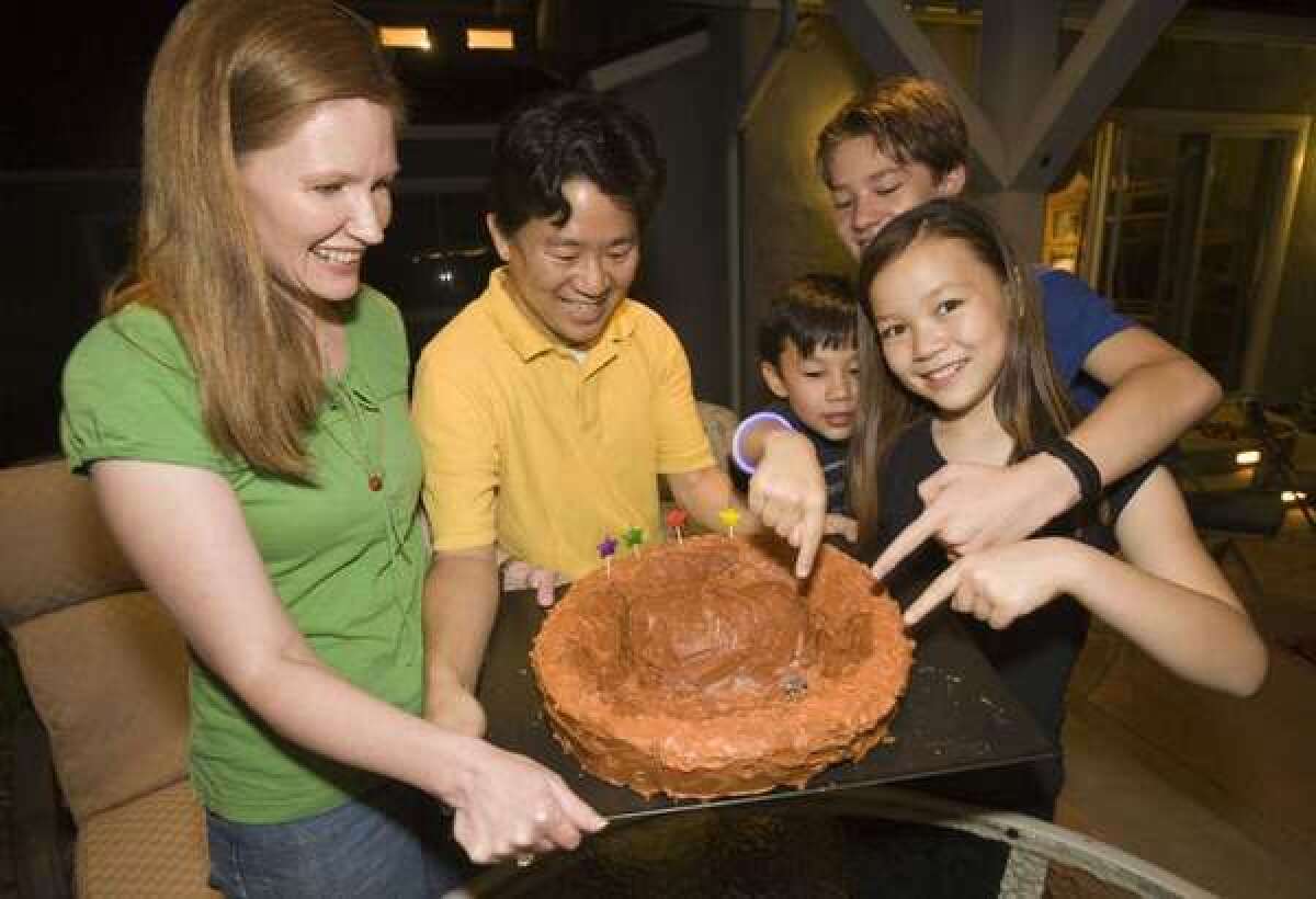 David Oh with his wife, Bryn, left, and their sons Devyn and Braden and daughter Ashlyn, show their Mars cake during a late-night dinner at their home in La Canada Flintridge. David, a Jet Propulsion Laboratory engineer on NASA's Mars Science Laboratory mission, has worked on Mars time during the Curiosity rover mission. His family joined him on the schedule for a month.