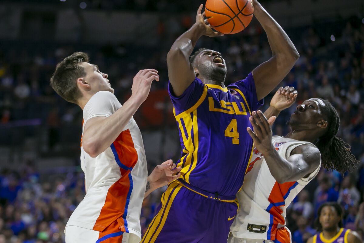 LSU forward Darius Days (4) drives for the basket between Florida forward Colin Castleton, left, and Florida forward Anthony Duruji during the first half of an NCAA college basketball game Wednesday, Jan. 12, 2022, in Gainesville, Fla. (AP Photo/Alan Youngblood)