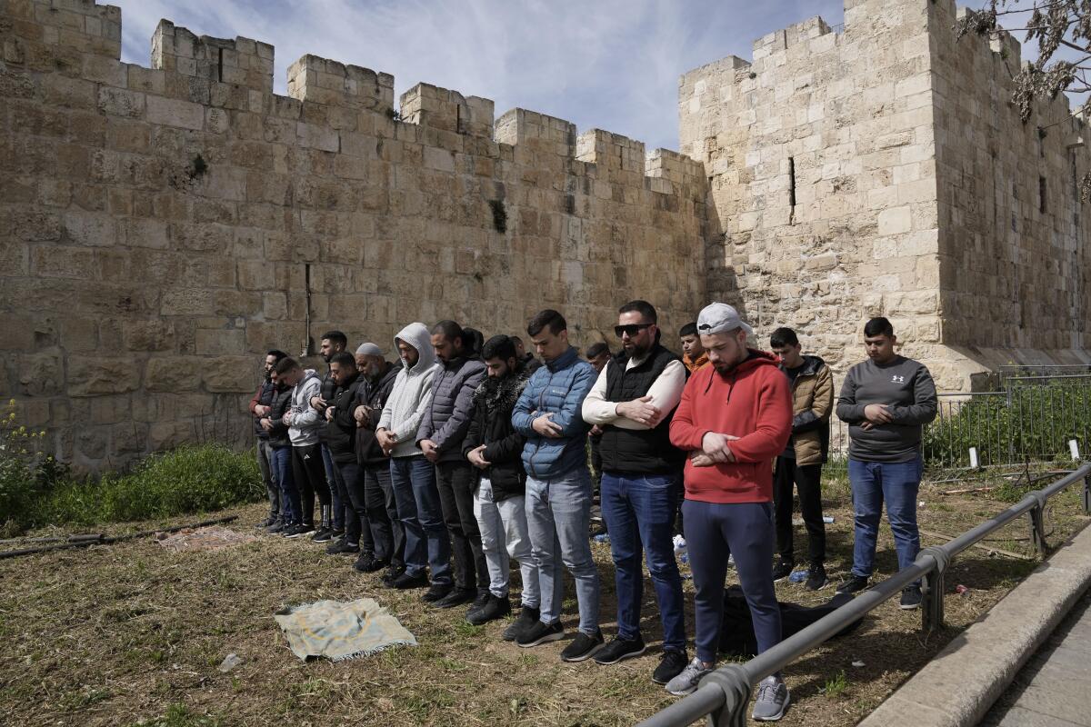 Palestinian Muslims pray outside of the walls of the Old City of Jerusalem.
