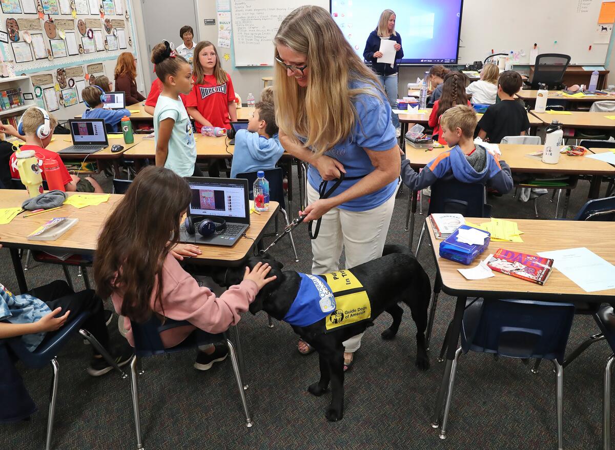 Guide dog trainer Elizabeth Pavloff of Huntington Beach introduces Jada at Hope View Elementary School on Wednesday.