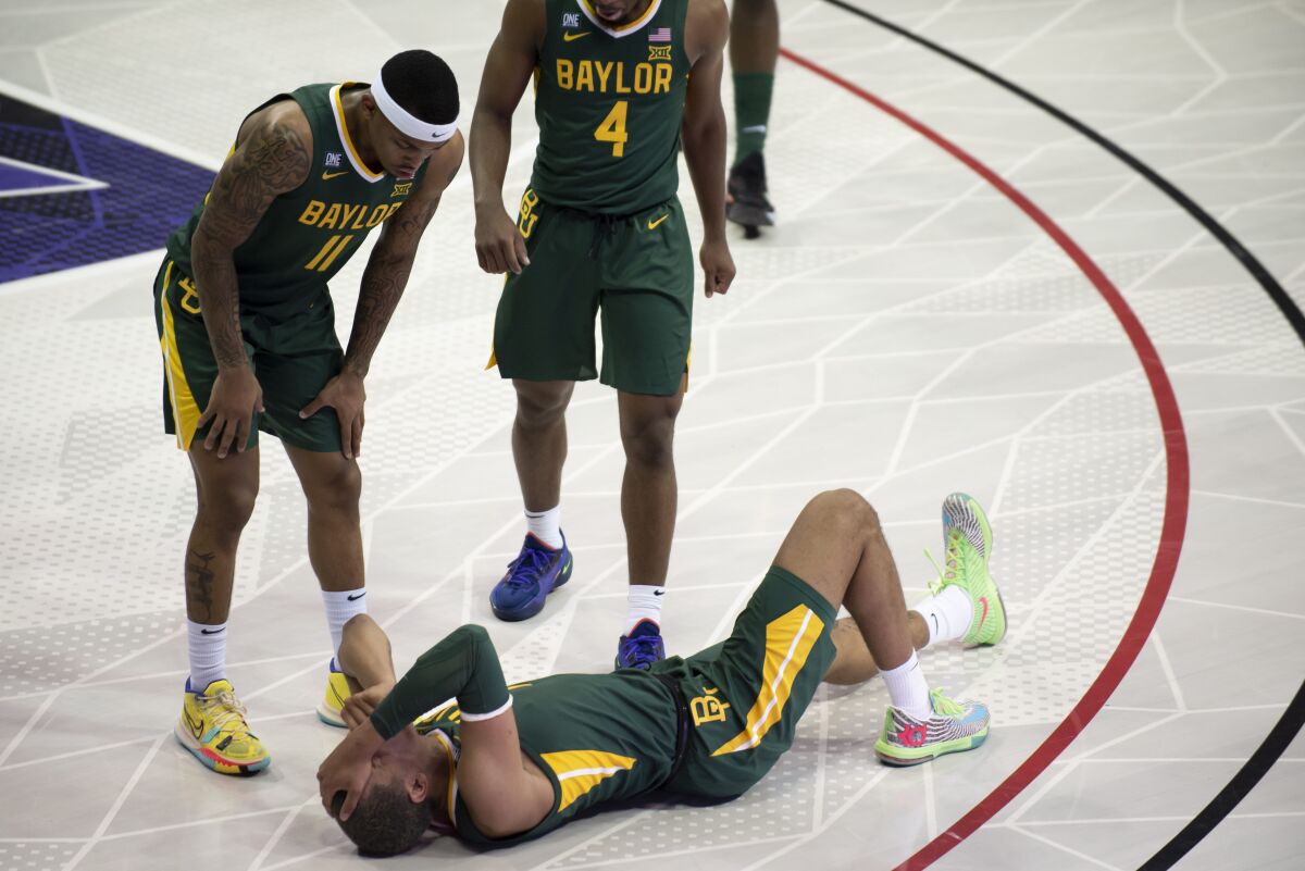 FILE - Baylor forward Jeremy Sochan, bottom, covers his face after getting injured on a play in the first half of an NCAA college basketball game against TCU in Fort Worth, Texas, Saturday, Jan. 8, 2022. Baylor has gotten banged up over the last month, going from the undefeated No. 1 team to 4-4 over its last eight games. (AP Photo/Emil Lippe, File)
