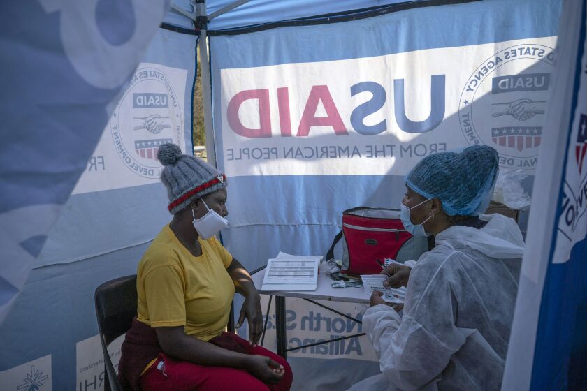 FILE - In this July 2, 2020 file photo, nurse Nomautanda Siduna, right, talks to a patient who is HIV-positive inside a gazebo used as a mobile clinic in Ngodwana, South Africa. Researchers are stopping a study early after finding that a shot of an experimental medicine every two months worked better than daily Truvada pills to help keep uninfected women from catching HIV from an infected sex partner. The news is a boon for AIDS prevention efforts especially in Africa, where the study took place, and where women have few discreet ways of protecting themselves from infection. (AP Photo/Bram Janssen, File)
