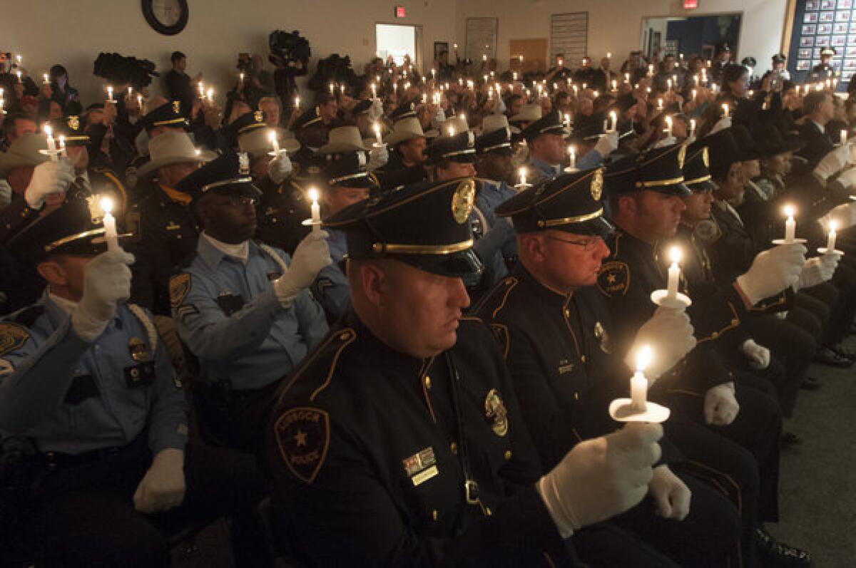 Police officers from throughout Texas hold candles during a ceremony commemorating slain Dallas Police Officer J.D. Tippit, who was killed by Lee Harvey Oswald. The event was held after the memorial for President Kennedy in Dallas on Friday.