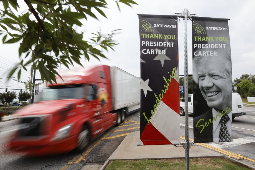 Motorists pass a sign dedicated to former President Jimmy Carter along Jimmy Carter Blvd. on Tuesday, May 23, 2023, in Norcross, Ga. (AP Photo/Alex Slitz)