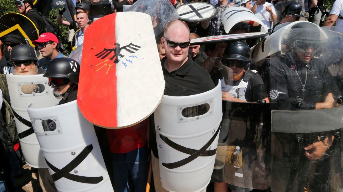 White nationalist demonstrators use shields as they guard the entrance to Lee Park in Charlottesville, Va., on Saturday.