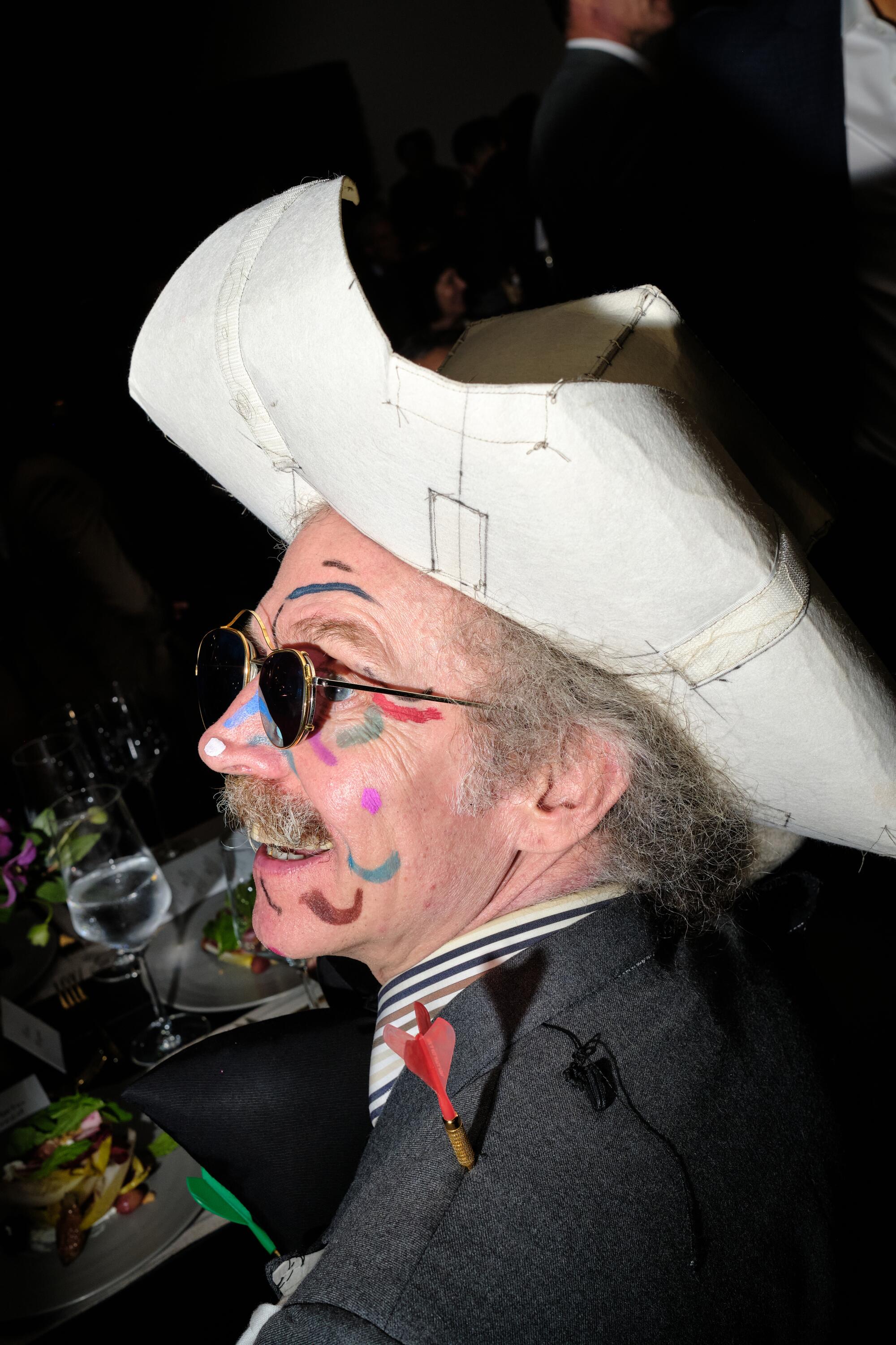 Martin Creed sports face paint and a big hat.