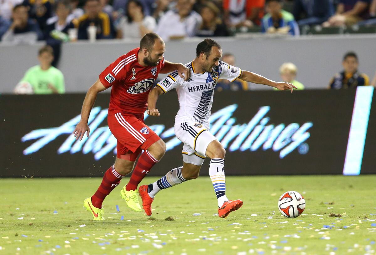 Galaxy's Landon Donovan races for the ball against Dallas' Adam Moffat at StubHub Center on Saturday night.