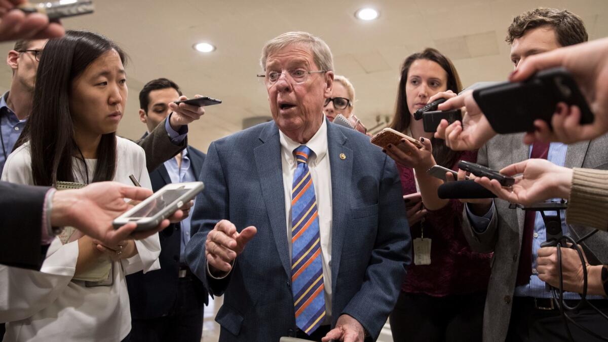 Sen. Johnny Isakson (R-Ga.) takes questions from reporters on Capitol Hill in Washington. A provision he added to the tax reform bill that would charge certain foreign airlines higher taxes was removed from the bill's final version.
