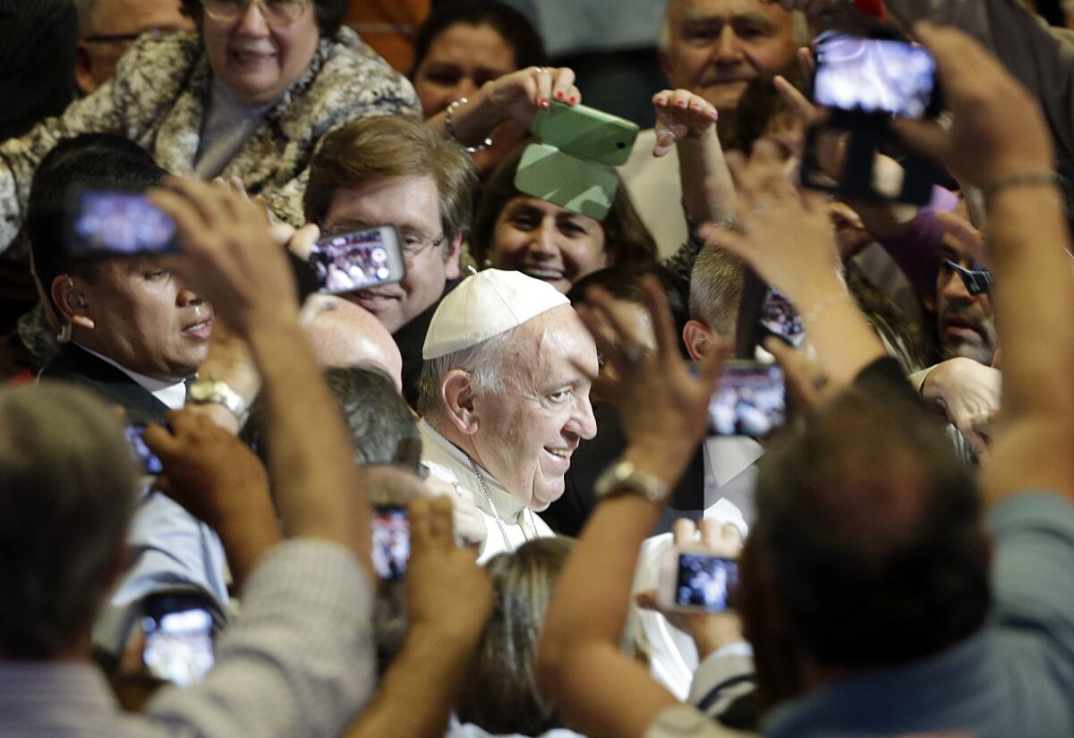 En esta foto del 11 de julio de 2015, el papa Francisco es rodeado por la gente que le toma fotografías a su arribo a un encuentro con representantes de la sociedad civil en la escuela San José en su visita a Asunción, Paraguay. Cinco organizaciones católicas hispanas en EEUU lanzarán en agosto una campaña nacional por las redes sociales para que la comunidad latina le dé la bienvenida cuando visite ese país en septiembre.