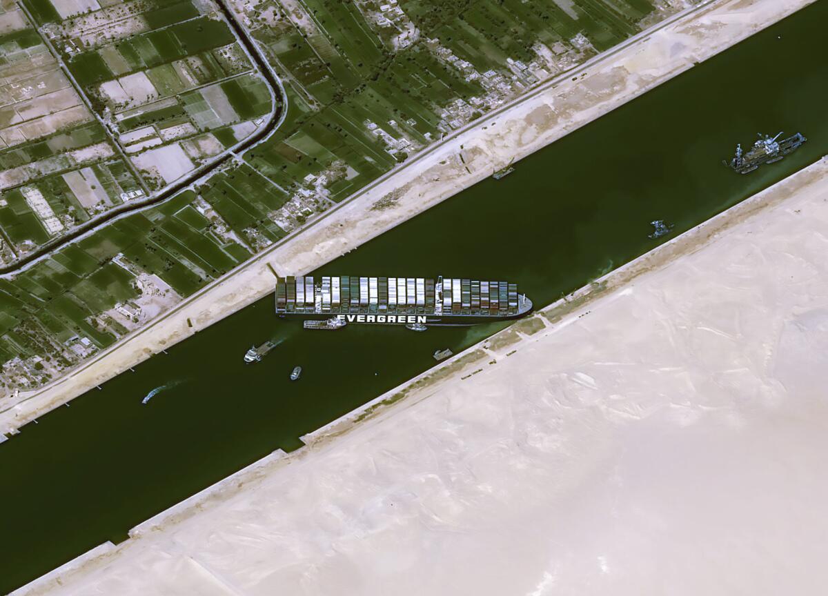 Overhead view of the cargo ship Ever Given stuck sideways in the Suez Canal.