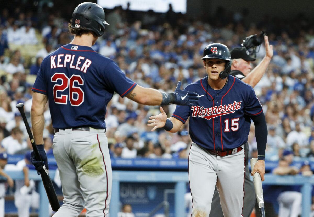 Gio Urshela, right, celebrates with Minnesota Twins teammate Max Kepler after scoring against the Dodgers on Aug. 9.