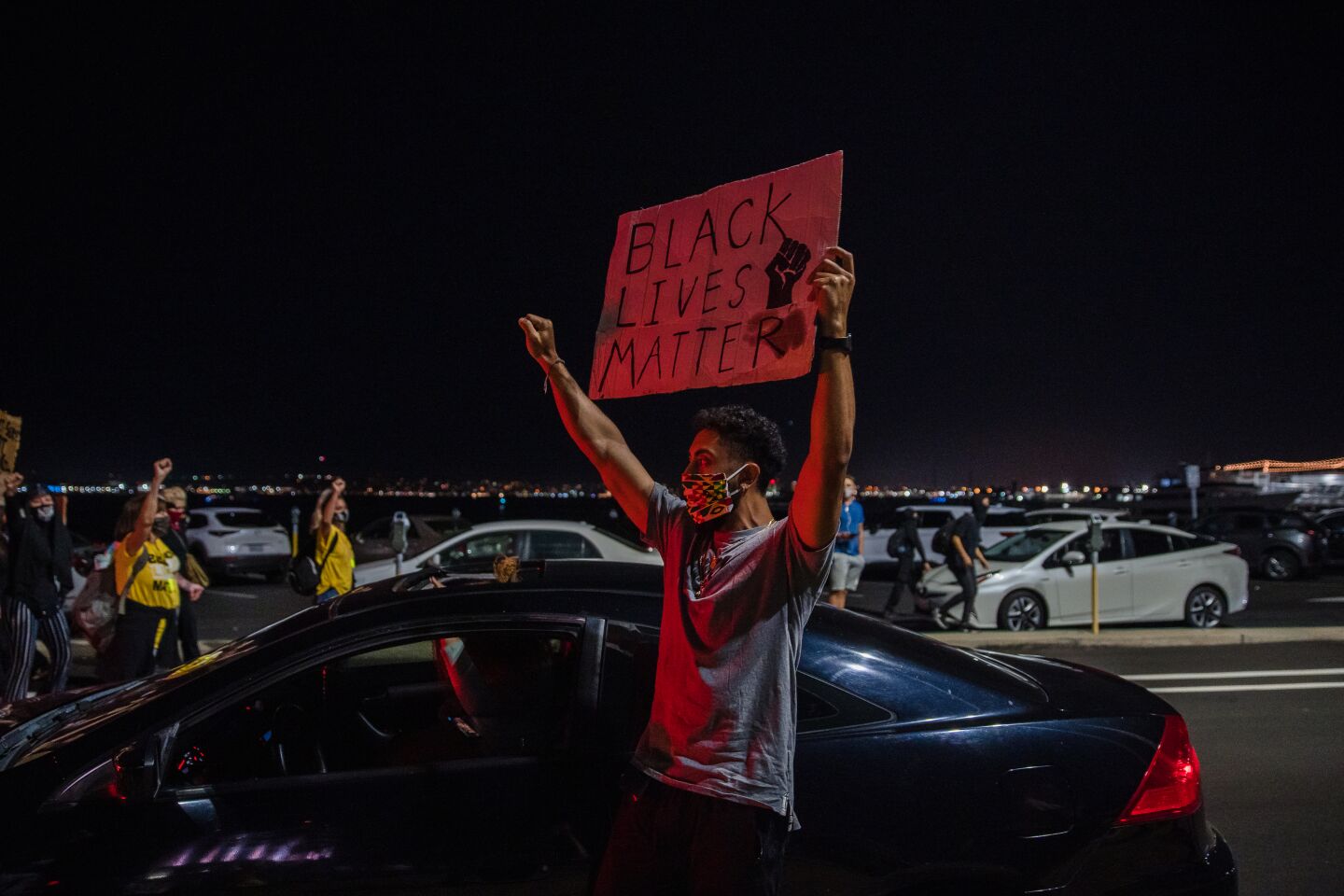 A young man gets out of his car to show solidarity as protesters march through downtown San Diego on September 23, 2020.