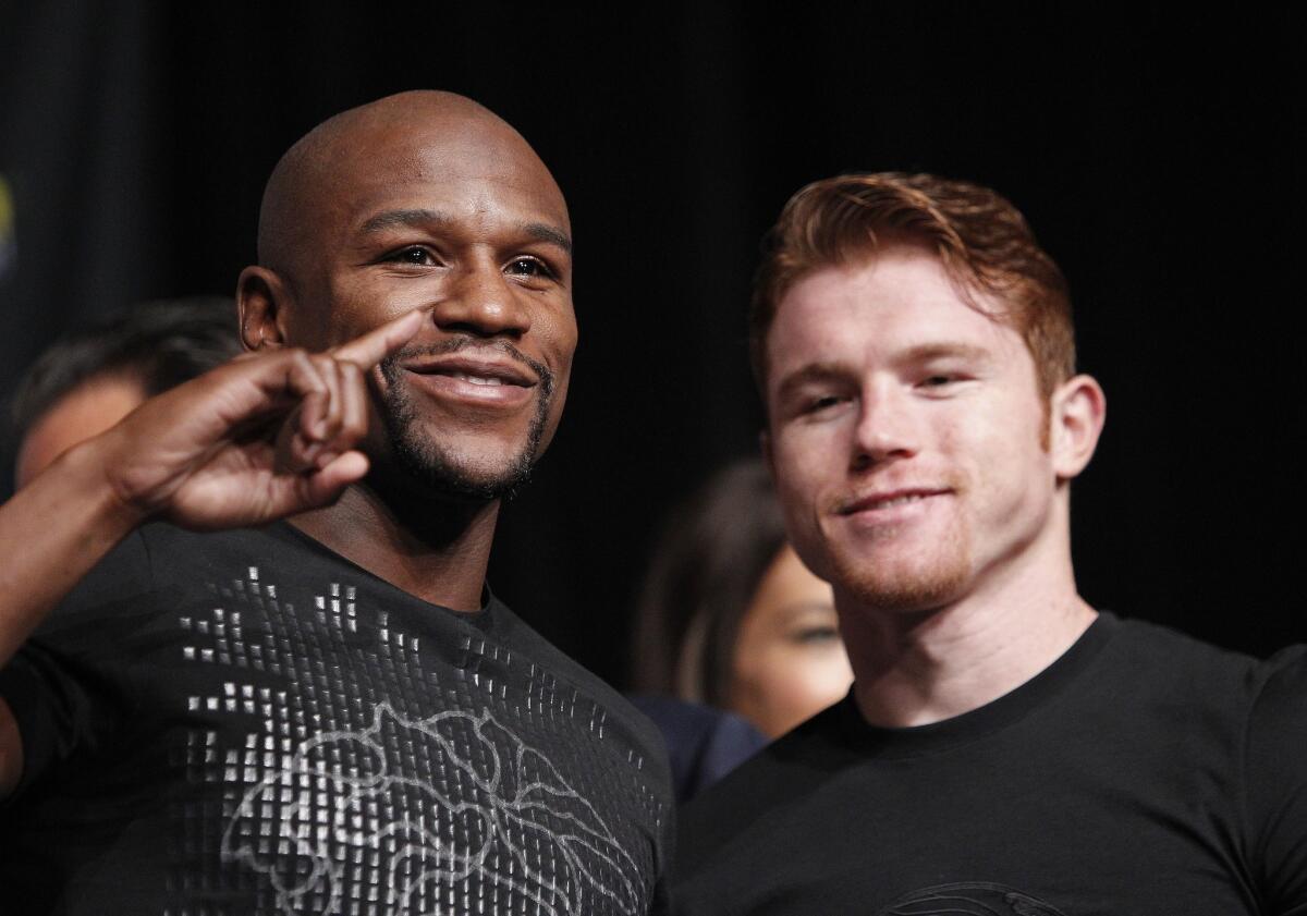 Floyd Mayweather Jr., left, and Saul "Canelo" Alvarez pose during a news conference Wednesday in Las Vegas to promote their fight on Saturday.