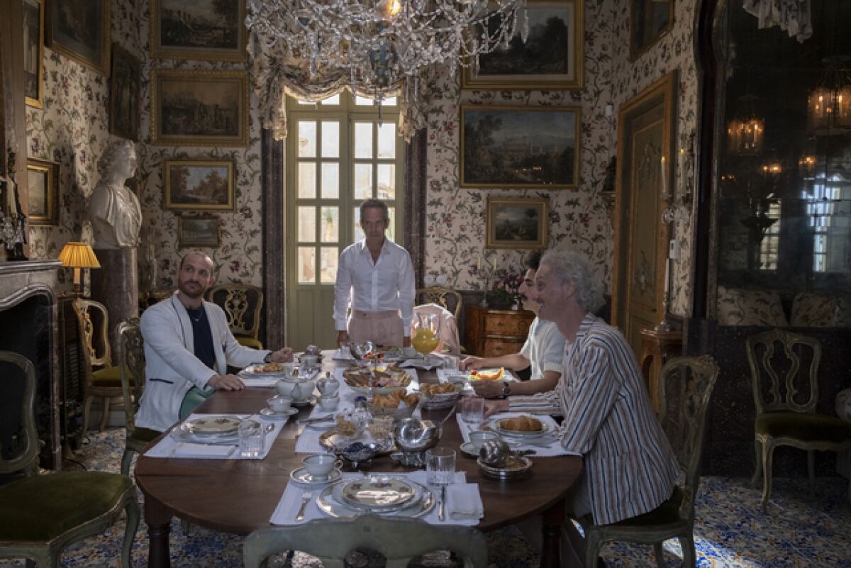 A group of stylish men sitting around a dining room table