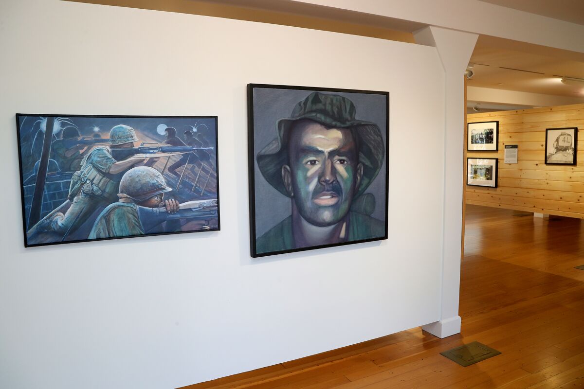 Two paintings of soldiers hang in a gallery.