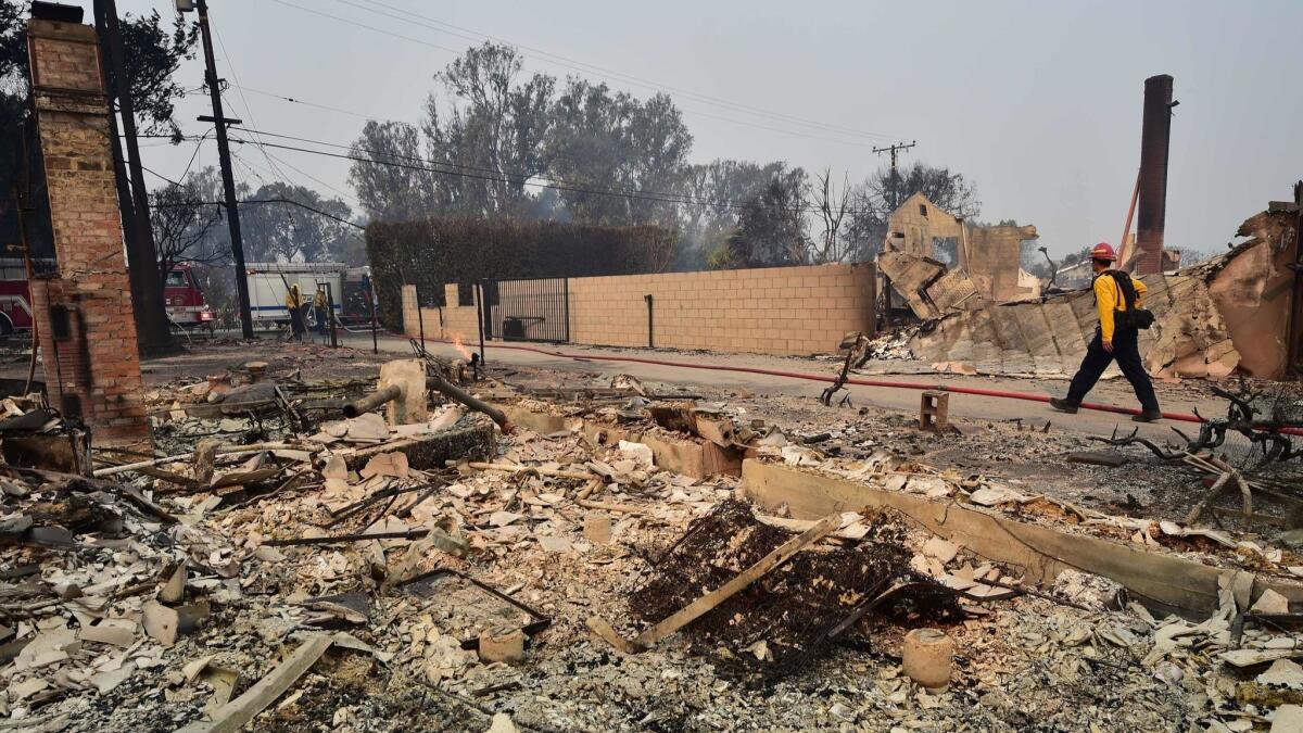 A firefighter walks past property destroyed in the Point Dume neighborhood of Malibu Satirday after the Woolsey Fire tore through the neighborhood overnight.