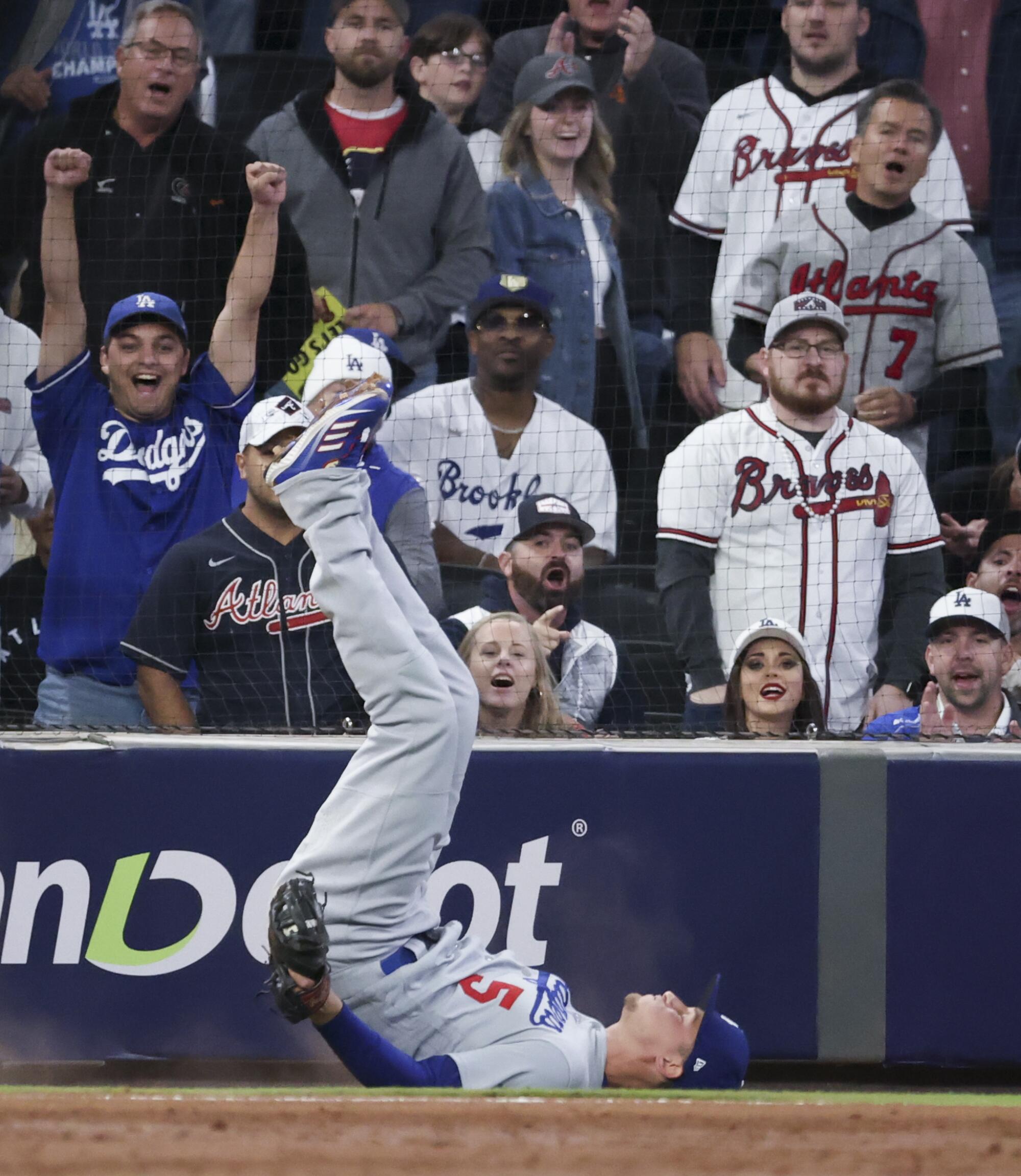Dodgers shortstop Corey Seager falls after catching a pop up fly by Braves' Joc Pederson