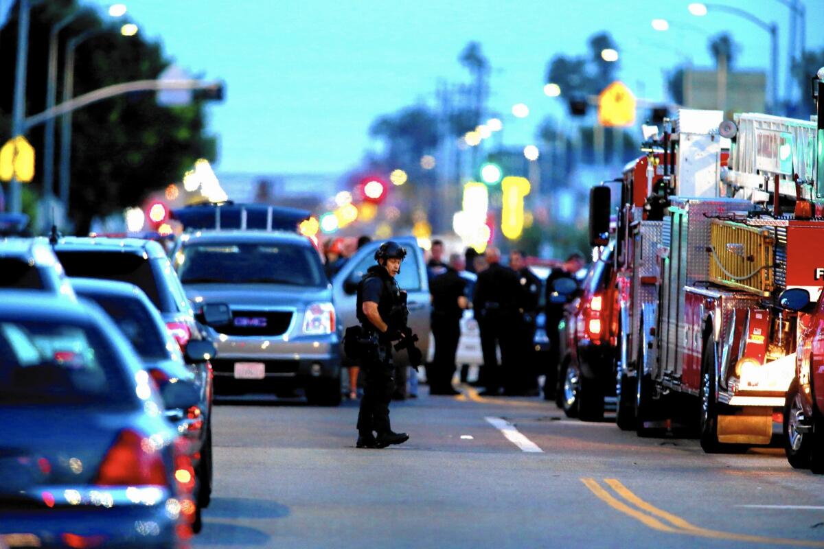 Officials gather at the intersection of 65th Street and Broadway in South L.A., where two LAPD plainclothes officers were shot at.