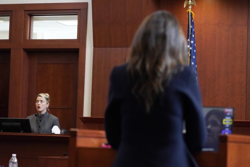 A woman on the witness stand, left, is questioned by a female attorney, seen from behind