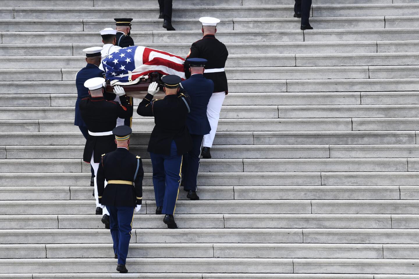 The flag-draped casket of the late Rep. John Lewis, D-Ga., is carried by a joint services military honor guard up the steps of the East front steps of Capitol Hill in Washington Monday.