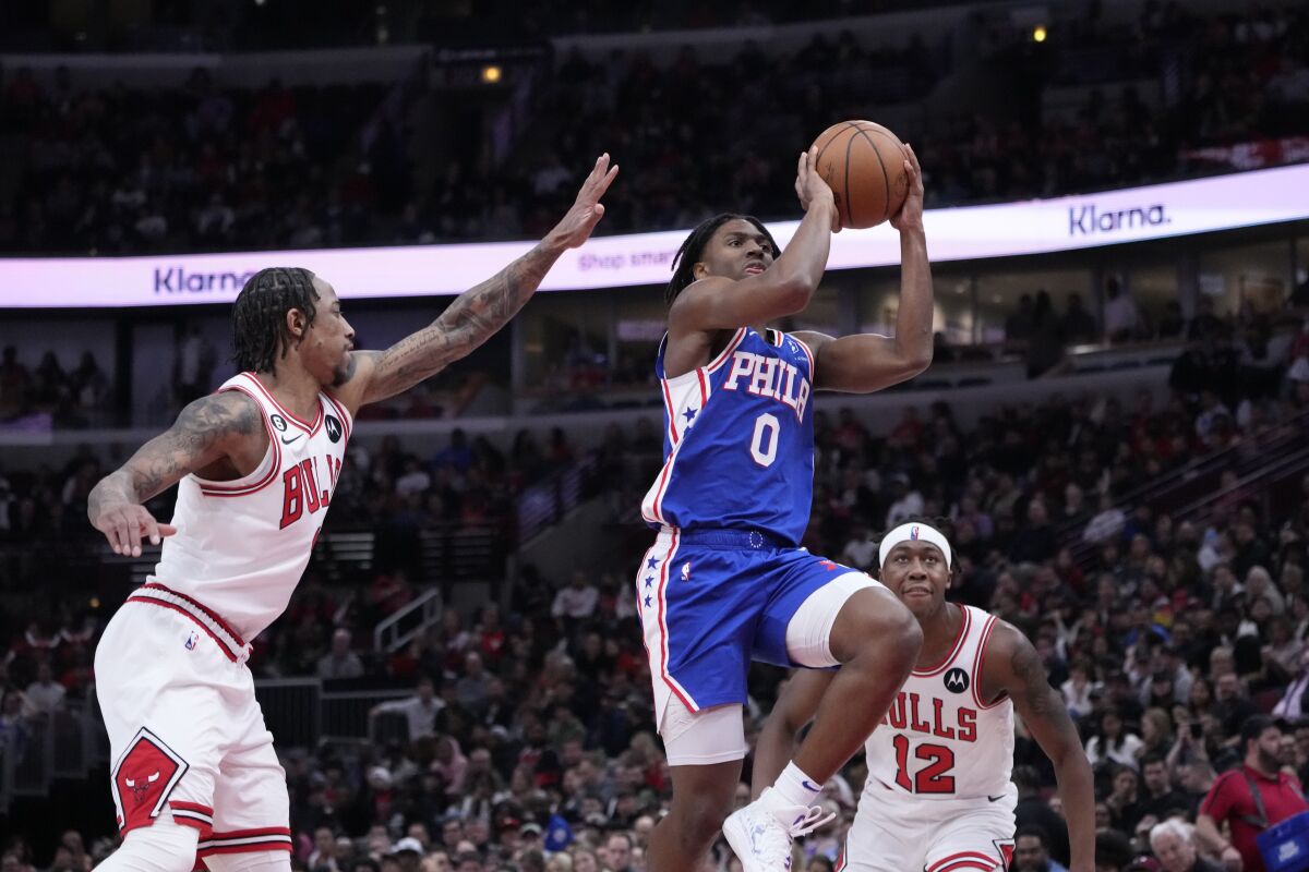 Philadelphia 76ers' Tyrese Maxey drives to the basket past Chicago Bulls' DeMar DeRozan, left, and Ayo Dosunmu during the first half of an NBA basketball game Wednesday, March 22, 2023, in Chicago. (AP Photo/Charles Rex Arbogast)