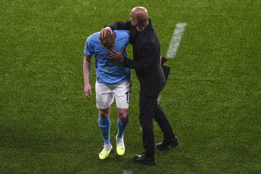 Manchester City's head coach Pep Guardiola greets Kevin De Bruyne as he walks off the pitch to be replaced during the Champions League final soccer match between Manchester City and Inter Milan at the Ataturk Olympic Stadium in Istanbul, Turkey, Saturday, June 10, 2023. (AP Photo/Thanassis Stavrakis)