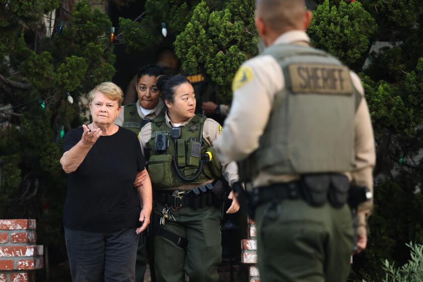 Los Angeles County sheriff's deputies escort Los Angeles Supervisor Sheila Kuehl from her house. 