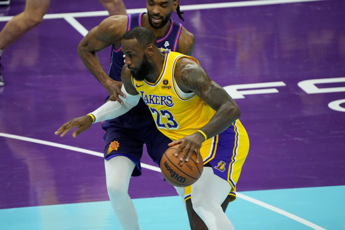 Lakers forward LeBron James, right, drives against the Phoenix Suns.