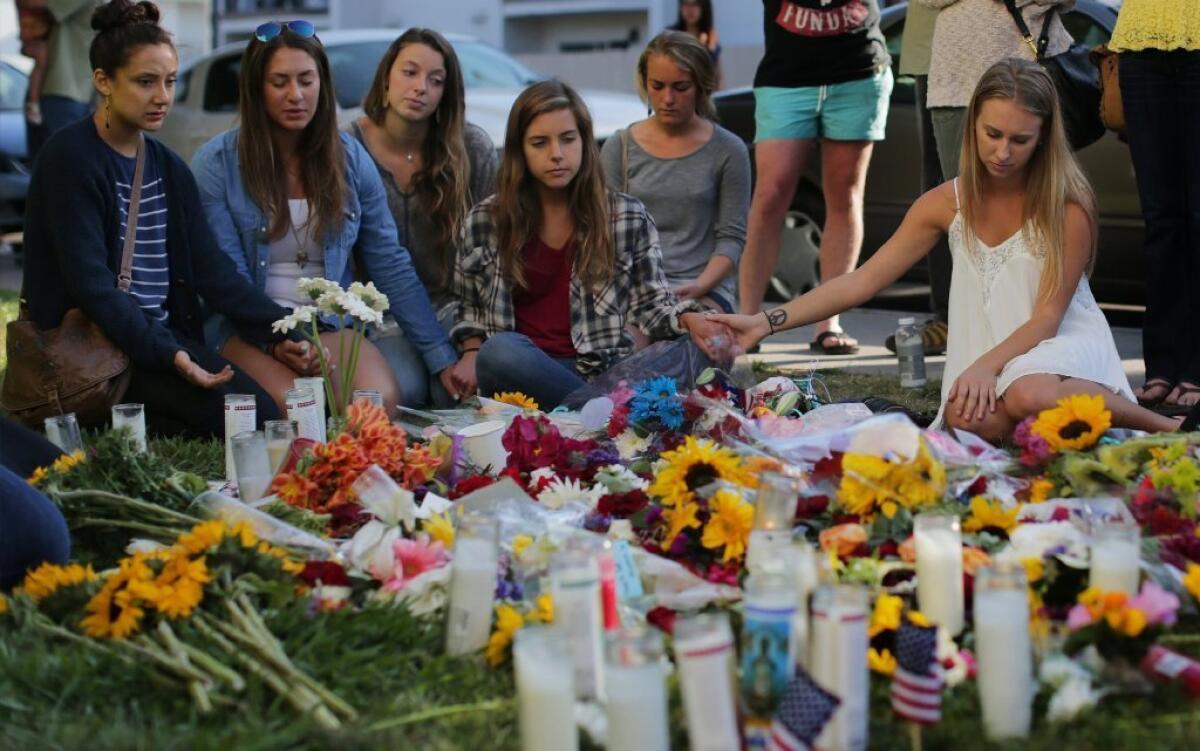 Friends hold hands as they remember Veronika Weiss and Katherine Cooper outside the Alpha Phi sorority house in Isla Vista, where the two young women were gunned down Friday.