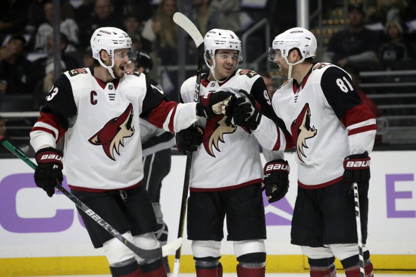 FILE - In this Saturday, Nov. 23, 2019, file photo, Arizona Coyotes center Phil Kessel, right, celebrates his goal with defenseman Oliver Ekman-Larsson, left, of Sweden, and center Clayton Keller, center, during the first period of an NHL hockey game against the Los Angeles Kings in Los Angeles. Bolstered by a taste of playoff success, the Coyotes are aiming to go even deeper in a unique 2021 season with roster additions who are expected to add a level of toughness and tenacity. (AP Photo/Alex Gallardo, File)