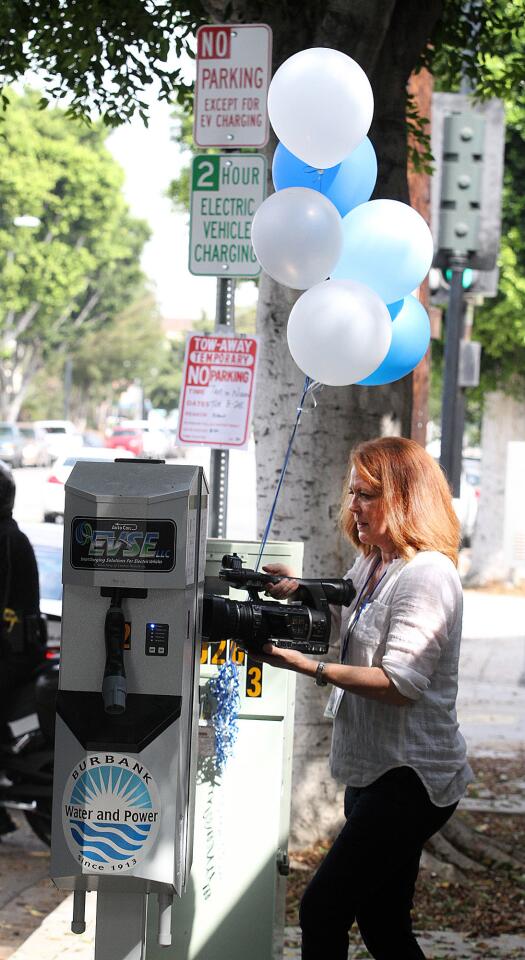 Colleen Felix, with the city of Burbank's Public Information Office, takes video of a newly installed EV charging station on Hollywood Way on Tuesday, Aug. 25, 2015.