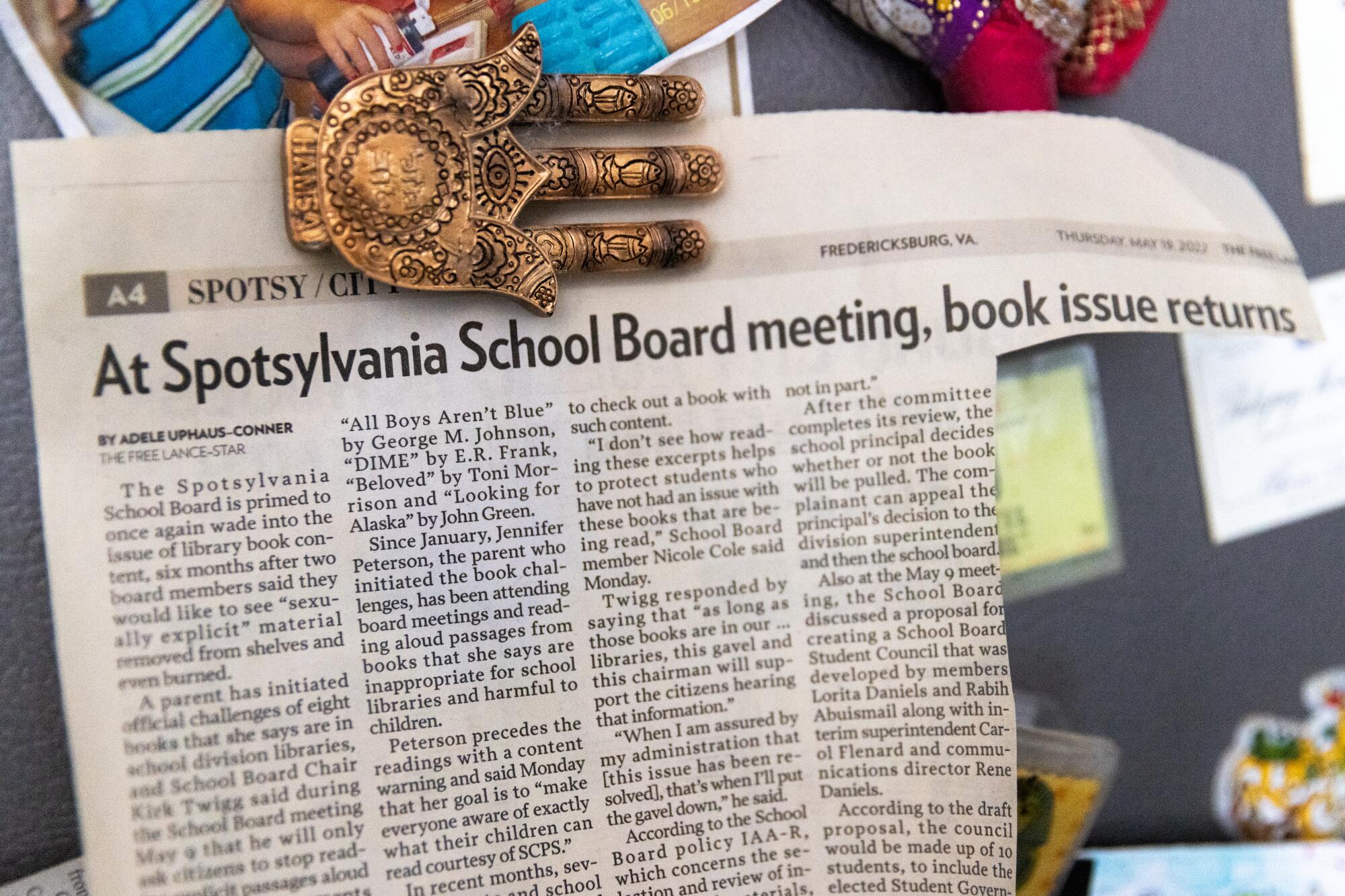 A Hamsa Hand magnet holds a May 2022 Free LanceStar newspaper clipping about book 