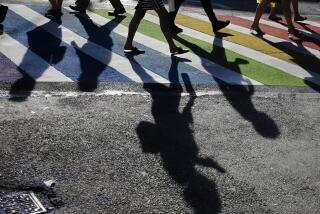FILE - Pedestrians cross the intersection of Christopher Street and Seventh Avenue near the Stonewall Inn on June 27, 2019, in New York. The Human Rights Campaign declared a state of emergency for LGBTQ+ people in the U.S. on Tuesday, June 6, 2023, and a released “a guidebook for action” summarizing what it calls discriminatory laws in each state, along with “know your rights” information and health and safety resources. (AP Photo/Frank Franklin II, File)