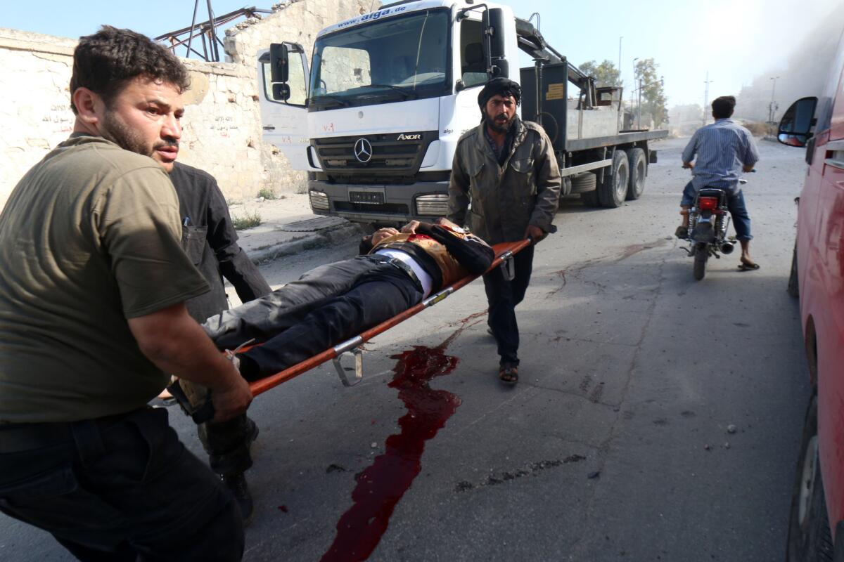 Syrians carry a victim of a reported barrel-bomb attack by government forces on the Muasalat area of Aleppo.