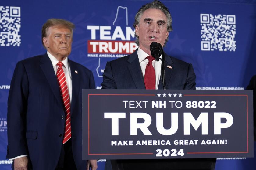 FILE - Republican presidential candidate former President Donald Trump listens as former Republican presidential candidate, North Dakota Gov. Doug Burgum, speaks on stage during a campaign event in Laconia, N.H., Jan. 22, 2024. (AP Photo/Matt Rourke, File)
