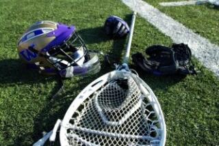 Lacrosse equipment on the sideline of a field.